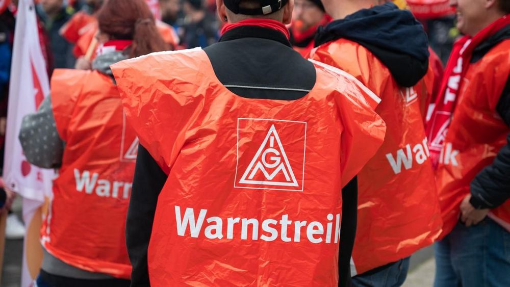 sr-bei-einer-demonstration-der-ig-metall-stehen-arbeiter-mit-ig-metall-westen-zusammen-100.jpg
